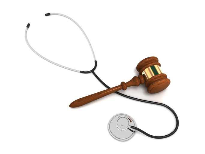 A wooden judge's gavel placed next to a stethoscope, symbolizing the intersection of healthcare and legal regulations such as HIPAA and GDPR compliance.